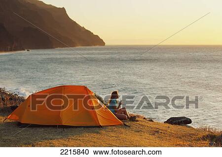 Hawaii, Kauai, Na Pali Coast, View of the Kalalau Mountains and ocean, Female camper enjoys the scenery. View Large Photo Image Stock Image - Hawaii, Kauai, Na Pali Coast, View of the Kalalau Mountains and ocean, Female camper enjoys the scenery.. Fotosearch