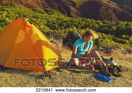 Hawaii, Kauai, Na Pali Coast, View of the Kalalau Mountains, Female camper heating her drink at campsite. View Large Photo Image Stock Image - Hawaii, Kauai, Na Pali Coast, View of the Kalalau Mountains, Female camper heating her drink at campsite.. Fotosearch