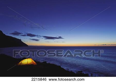 Hawaii, Kauai, Na Pali Coastline and Kalalau Mountains, Iluminated tent at dusk. View Large Photo Image Stock Photograph - Hawaii, Kauai, Na Pali Coastline and Kalalau Mountains, Iluminated tent at dusk.. Fotosearch
