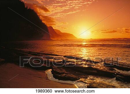 Stock Image - Hawaii, Kauai, Napali Coast At Sunset, Bright Orange Sky And Calm Ocean.. Fotosearch