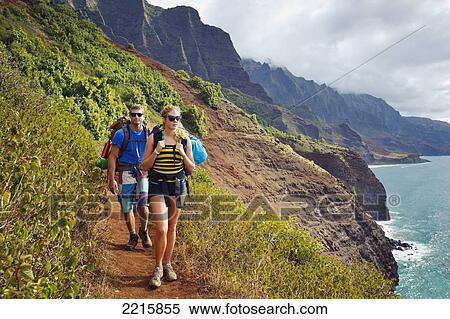 Hawaii, Kauai, Napali Coast, Young Couple Hiking on the Napali Coast Trail. View Large Photo Image Stock Photography - Hawaii, Kauai, Napali Coast, Young Couple Hiking on the Napali Coast Trail.. Fotosearch
