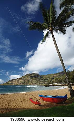 Stock Photograph - Hawaii, Kauai, Nawiliwili, Kalapaki Beach And Bay, Red Outrigger Canoe On Beach.. Fotosearch