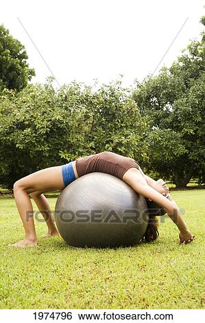 Stock Photograph - Hawaii, Kauai, North Shore, Beautiful Girl Excercising On Grassy Field.. Fotosearch