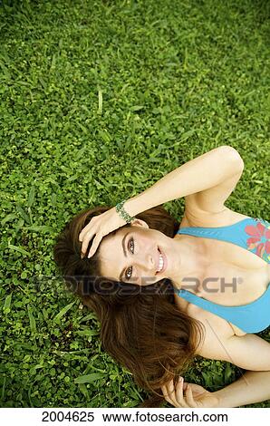 Stock Photography - Hawaii, Kauai, North Shore, Brunette Model Poses In Grass.. Fotosearch