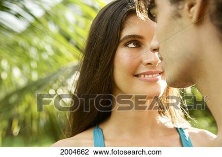 Stock Image - Hawaii, Kauai, North Shore, Couple Gaze Into Eachothers Eyes.. Fotosearch