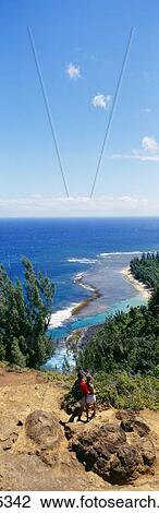 Stock Image - Hawaii, Kauai, North Shore, Couple Overlooking Ke'e Beach. Fotosearch