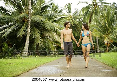 Hawaii, Kauai, North Shore, Couple Walk Along Path Holding Hands. View Large Photo Image Stock Photo - Hawaii, Kauai, North Shore, Couple Walk Along Path Holding Hands.. Fotosearch