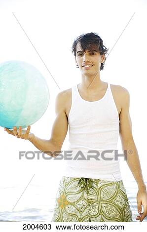 Hawaii, Kauai, North Shore, Handsome Guy Holds Ball While Standing In Ocean. View Large Photo Image Stock Image - Hawaii, Kauai, North Shore, Handsome Guy Holds Ball While Standing In Ocean.. Fotosearch