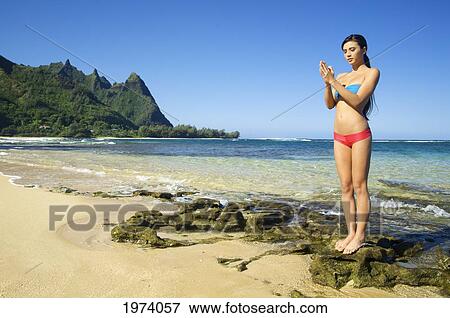 Stock Photo - Hawaii, Kauai, North Shore, Tunnels Beach, Woman Doing Yoga.. Fotosearch