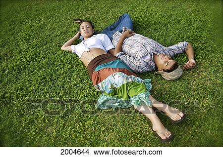Hawaii, Kauai, North Shore, Young Couple Take A Nap In Grass. View Large Photo Image Picture - Hawaii, Kauai, North Shore, Young Couple Take A Nap In Grass.. Fotosearch