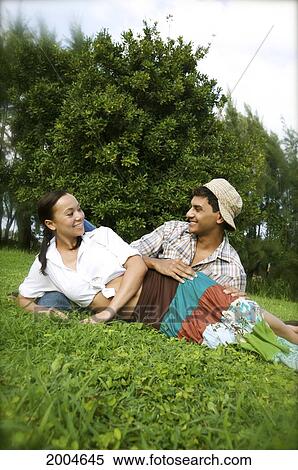Hawaii, Kauai, North Shore, Young Couple Admire Eachother While Laying In Grass. View Large Photo Image Stock Photography - Hawaii, Kauai, North Shore, Young Couple Admire Eachother While Laying In Grass.. Fotosearch