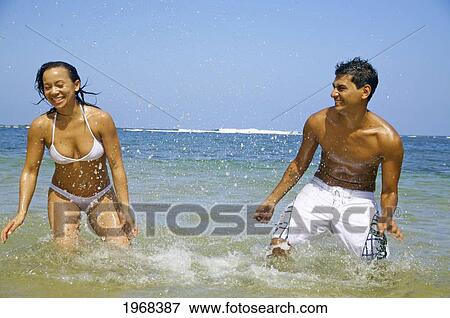 Stock Photo - Hawaii, Kauai, Pila'a, Beautiful Couple In The Water Having Fun.. Fotosearch