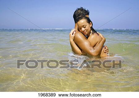 Stock Photo - Hawaii, Kauai, Pila'a, Beautiful Couple Holding Each Other In The Water.. Fotosearch