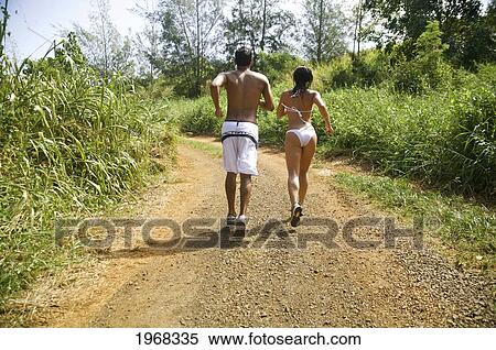 Hawaii, Kauai, Pila'a, Young Fit Couple Jogging On The Bike Path, Motion. View Large Photo Image Stock Photography - Hawaii, Kauai, Pila'a, Young Fit Couple Jogging On The Bike Path, Motion.. Fotosearch