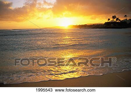 Stock Image - Hawaii, Kauai, Poipu, Brennecke's Beach At Sunset, Colorful Shimmery Shoreline, Ocean Reflections. Fotosearch