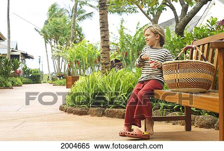Hawaii, Kauai, Poipu, Kukuiula Shopping Village, Young Boy On Bench Along Walkway. View Large Photo Image Stock Photography - Hawaii, Kauai, Poipu, Kukuiula Shopping Village, Young Boy On Bench Along Walkway.. Fotosearch