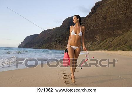 Hawaii, Kauai, Polihale Beach, Woman Walking Along Sandy Shore With Snorkel Gear, Evening Glow. View Large Photo Image Stock Image - Hawaii, Kauai, Polihale Beach, Woman Walking Along Sandy Shore With Snorkel Gear, Evening Glow.. Fotosearch