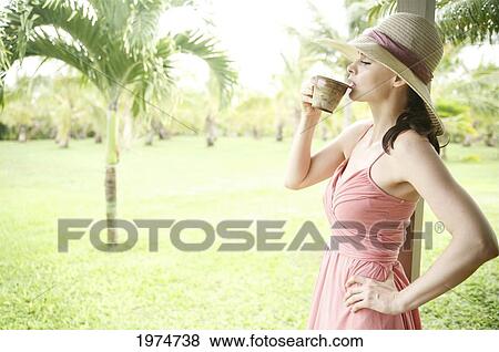 Hawaii, Kauai, Portrait Of A Beautiful Woman In A Pink Sundress Drinking Tea. View Large Photo Image Stock Photo - Hawaii, Kauai, Portrait Of A Beautiful Woman In A Pink Sundress Drinking Tea.. Fotosearch