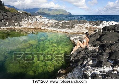 Hawaii, Kauai, Princeville, Queens Bath, Attractive Woman Sitting On Rocks. View Large Photo Image Stock Image - Hawaii, Kauai, Princeville, Queens Bath, Attractive Woman Sitting On Rocks.. Fotosearch