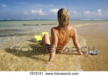 Stock Image - Hawaii, Kauai, Tunnels Beach, A Woman Wearing Yellow And Blue Fins On Beach.. Fotosearch