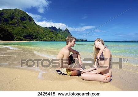Hawaii, Kauai, Tunnels Beach, a young man and woman sitting in the sand. View Large Photo Image Stock Photo - Hawaii, Kauai, Tunnels Beach, a young man and woman sitting in the sand.. Fotosearch