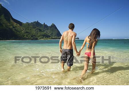 Stock Image - Hawaii, Kauai, Tunnels Beach, Beautiful Couple In The Water.. Fotosearch