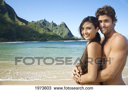 Stock Image - Hawaii, Kauai, Tunnels Beach, Beautiful Couple On The Beach.. Fotosearch