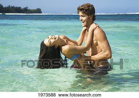 Stock Photo - Hawaii, Kauai, Tunnels Beach, Beautiful Couple In The Water.. Fotosearch