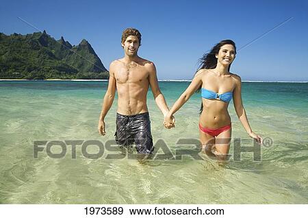 Stock Photo - Hawaii, Kauai, Tunnels Beach, Beautiful Couple In The Water.. Fotosearch