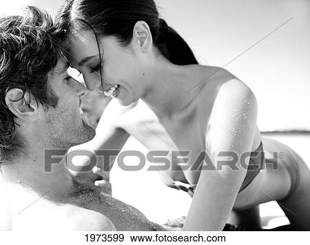 Stock Photo - Hawaii, Kauai, Tunnels Beach, Beautiful Couple On The Beach Having An Intimate Moment.. Fotosearch