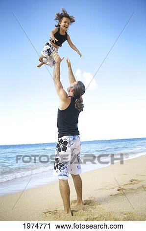 Stock Image - Hawaii, Kauai, Tunnels Beach, Dad With His Son Play Togteher.. Fotosearch