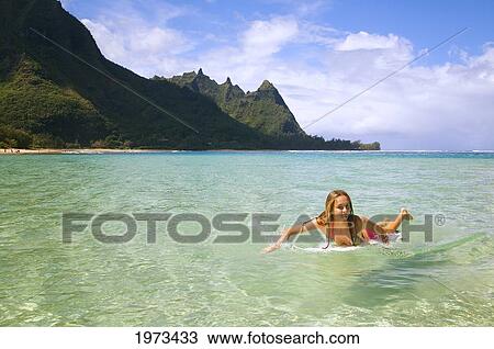 Stock Image - Hawaii, Kauai, Tunnels Beach, Surfer Girl Enjoying A Day Out.. Fotosearch