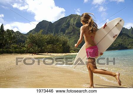 Stock Photograph - Hawaii, Kauai, Tunnels Beach, Surfer Girl Enjoying A Day Out.. Fotosearch