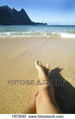 Hawaii, Kauai, Tunnels, Womans Legs Relaxing On The Sand. View Large Photo Image Stock Photography - Hawaii, Kauai, Tunnels, Womans Legs Relaxing On The Sand.. Fotosearch