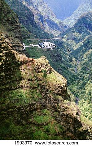 Stock Image - Hawaii, Kauai, Waimea Canyon, Helicopter Flying Above. Fotosearch