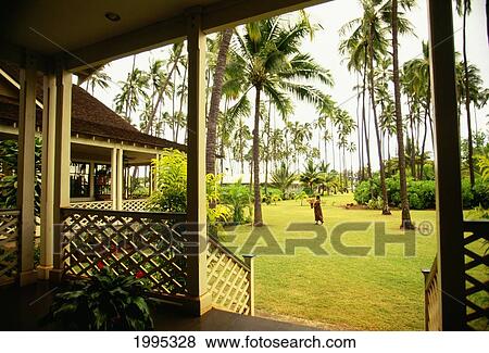 Stock Photo - Hawaii, Kauai, Waimea Plantation Cottages, Woman Walking Away. Fotosearch