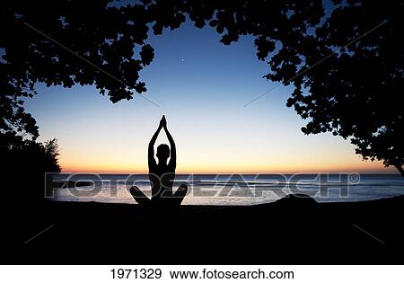 Hawaii, Kauai, Woman Meditating Along Ocean At Evening, Tree Silhouetted. View Large Photo Image Stock Photo - Hawaii, Kauai, Woman Meditating Along Ocean At Evening, Tree Silhouetted.. Fotosearch