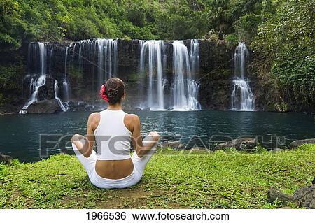 Stock Photograph - Hawaii, Kauai, Woman Sitting Near Kilauea Falls, View From Behind.. Fotosearch