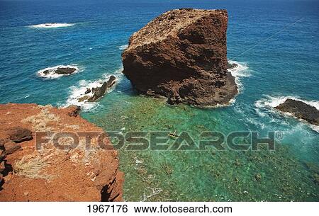 Stock Photograph - Hawaii, Lanai, Hulopoe Bay, View Of Pu'u Pehe Rock (Sweetheart Rock), Man Stand-Up Paddle Boarding.. Fotosearch