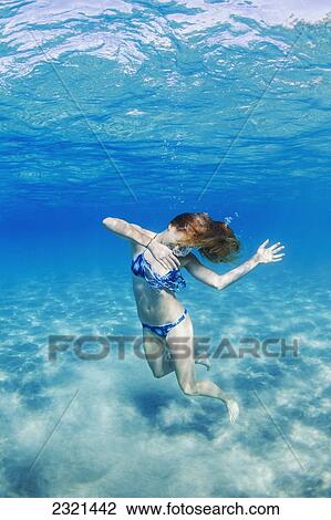 Stock Image - Hawaii, Lanai, Manele Bay, Young Woman Dancing In Shallow Water.. Fotosearch
