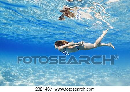 Stock Photo - Hawaii, Lanai, Manele Bay, Young Woman Swimming Near Ocean Surface.. Fotosearch