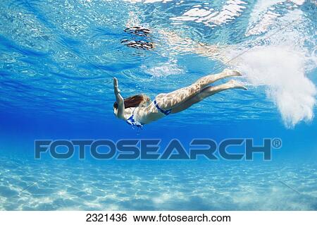Stock Photograph - Hawaii, Lanai, Manele Bay, Young Woman Swimming Near Ocean Surface.. Fotosearch