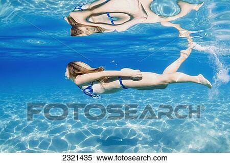 Stock Photography - Hawaii, Lanai, Manele Bay, Young Woman Swimming Near Ocean Surface.. Fotosearch