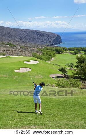 Stock Photo - Hawaii, Lanai, Woman Hitting A Tee Shot On The Challenge At Manele Golf Course.. Fotosearch