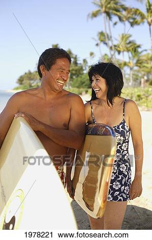 Hawaii, Local Couple Walking Along Beach With Surfboards. View Large Photo Image Stock Image - Hawaii, Local Couple Walking Along Beach With Surfboards.. Fotosearch