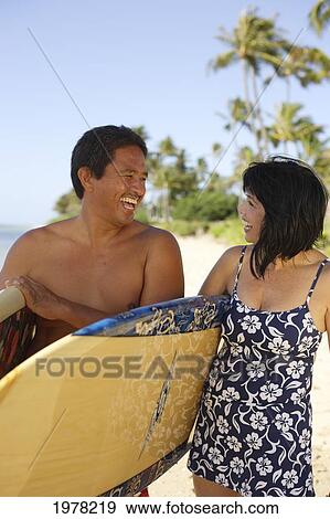 Hawaii, Local Couple Walking Along Beach With Surfboards. View Large Photo Image Stock Photo - Hawaii, Local Couple Walking Along Beach With Surfboards.. Fotosearch