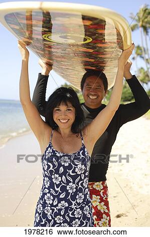 Hawaii, Local Couple Walking Along Beach With Surfboards. View Large Photo Image Stock Photograph - Hawaii, Local Couple Walking Along Beach With Surfboards.. Fotosearch
