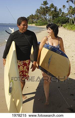 Hawaii, Local Couple Walking Along Beach With Surfboards. View Large Photo Image Stock Photography - Hawaii, Local Couple Walking Along Beach With Surfboards.. Fotosearch