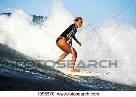 Stock Image - Hawaii, Local Woman Surfing Wave With Whitewater Spray. Fotosearch
