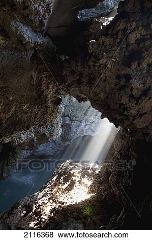 Stock Photo - Hawaii, Maui, A beam of light shines through into the Waianapanapa lava cave.. Fotosearch